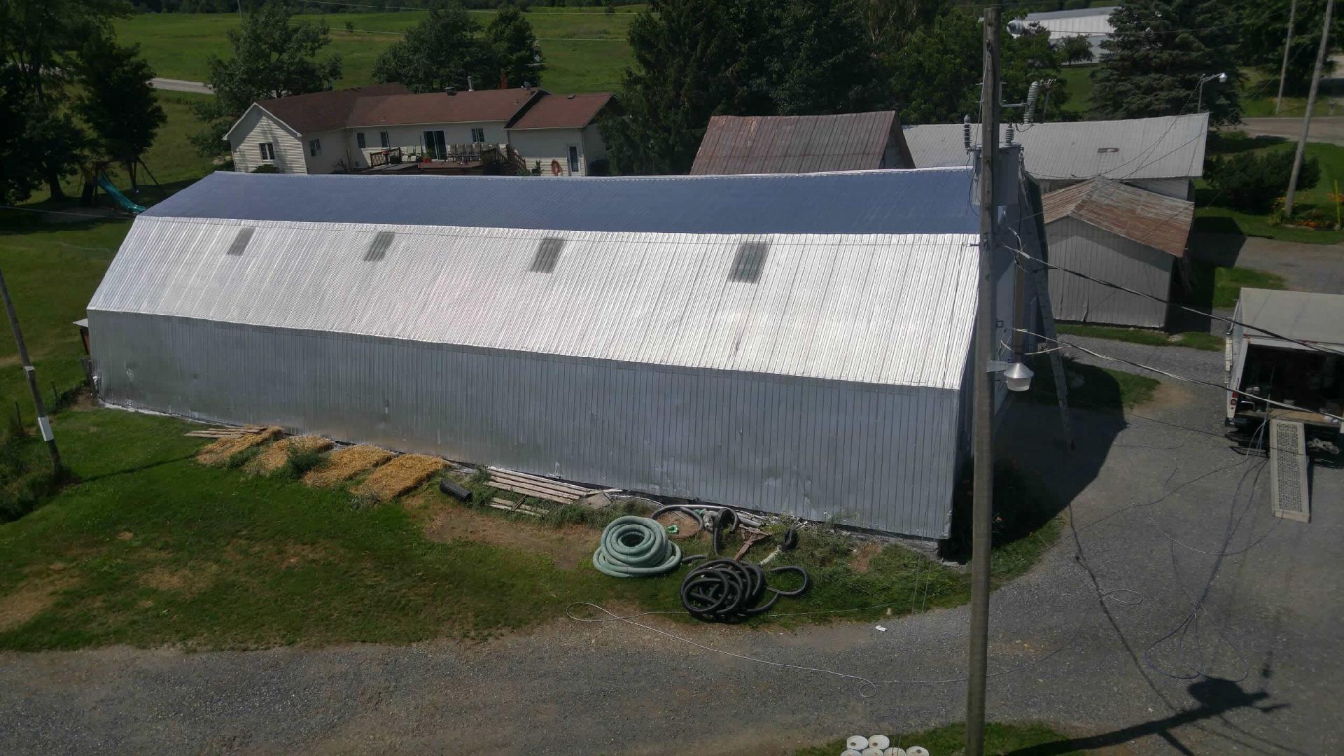 Vue d'un bâtiment agricole fraîchement peinturé au Québec, illustrant le prix d'un projet de peinture.